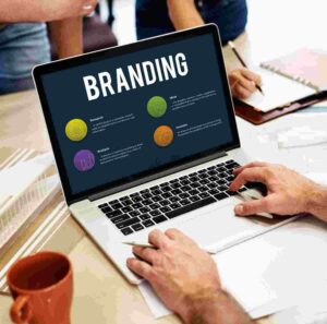 Branding strategy displayed on a laptop during a collaborative business meeting focused on building a distinctive brand.